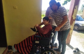 Fiziksel engelli genç kadın akülü tekerlekli sandalyesine...